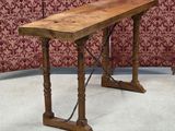 a wooden table that is sitting on the floor in front of a red wall
