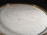 a close up of a table with a marble top and gold trim