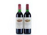 two bottles of red wine sitting next to each other on a white surface