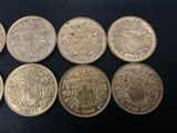 six different types of silver coins on a black surface