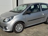 a small silver car parked in front of a garage