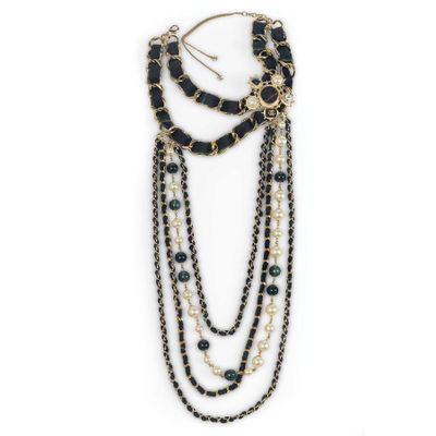 a close up of a necklace with black beads and pearls