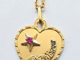 a close up of a heart shaped necklace with a star on it