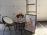 a table and chairs in a garage with a picture on the wall