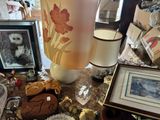 a table with a lamp, pictures, pictures, and other items on it
