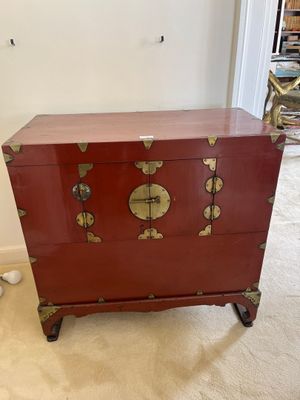une commode rouge surmontée de décorations dorées