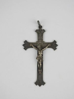 une croix métallique avec un crucifix sur fond blanc