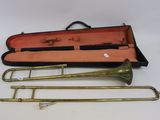 trois trombones en laiton dans un étui muni d'une poignée noire