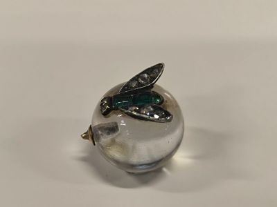 un gros plan d'une boule de verre sur laquelle repose une feuille verte