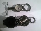 une boussole et une montre de poche posées sur une table
