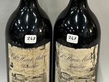 two bottles of red wine sitting next to each other on a table