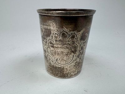 a silver cup sitting on a white surface