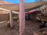 une photo d'une terrasse surmontée d'un grand parasol