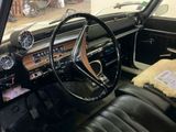 a dashboard and steering wheel of a car in a garage