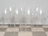 three clear plastic chairs sitting next to each other on a checkered floor