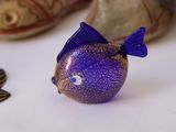 a blue fish figurine sitting on a table next to other items