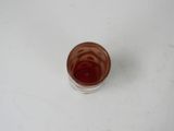 a glass of liquid sitting on a white surface