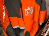 an orange and black jacket sitting on top of a pile of tools