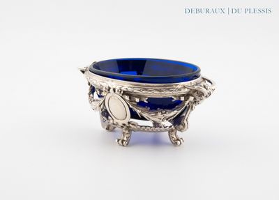 un bol en verre bleu posé sur un socle en argent