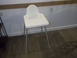 une chaise haute blanche dans une pièce dotée d'une fenêtre