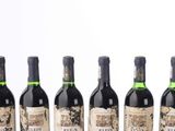 six bottles of wine are lined up on a table
