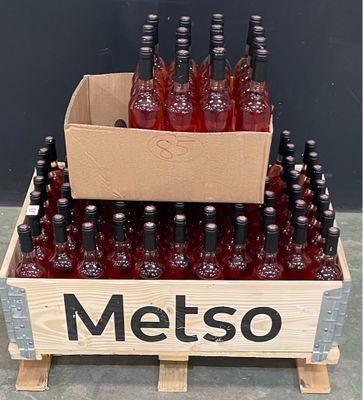 Les bouteilles de vin rouge se trouvent dans une caisse en bois posée sur une palette