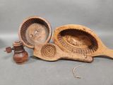 two wooden spoons and a bowl with a lid on a gray background