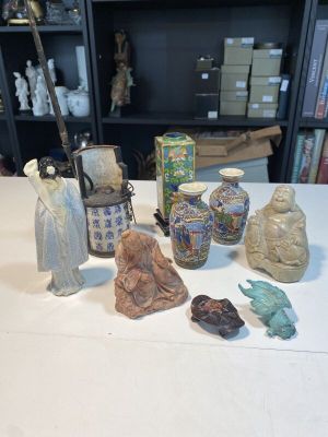 une table sur laquelle sont disposés de nombreux vases et statues