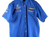 Le t-shirt est bleu et comporte un écusson du Canada.