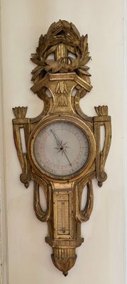 une horloge dorée accrochée au mur, dans un coin de la pièce