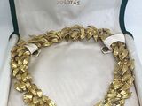 a close up of a gold bracelet in a case on a table
