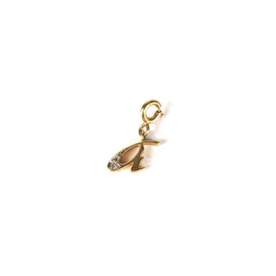 un gros plan d'un pendentif en or sur fond blanc