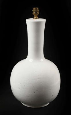 un vase blanc posé sur une surface noire