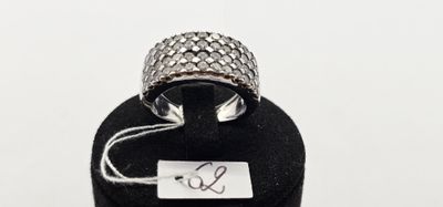 une photo d'une bague en argent sertie d'un diamant, posée sur un présentoir à bagues noir