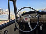 le volant et le tableau de bord d'une vieille voiture, avec un paquebot en arrière-plan