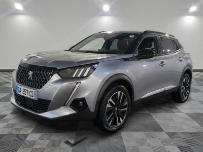un SUV argenté garé sur un sol en damier dans un garage