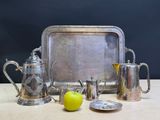 a silver tray with silverware and an apple next to it