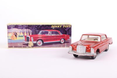 an old red toy car next to a boxed box of disney toys