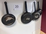 trois poêles accrochées au mur d'une cuisine
