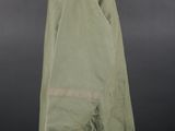a green jacket on a mannequin stand against a black background