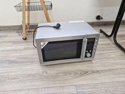 un micro-ondes posé par terre à côté d'une chaise