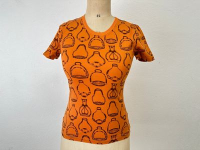 an orange shirt with a pattern of teapots and teapots on it