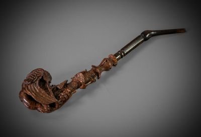une vieille pipe avec un tuyau en bois sur fond gris