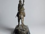 statue of a man on a horse with a rifle on a marble base
