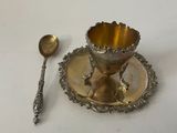 a silver plate with a spoon and a spoon rest on it