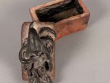 an image of a clay box with a statue of an elephant
