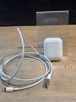 an apple airpods are sitting on a wooden table next to a charger