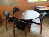 une table et des chaises dans une pièce où est accrochée une carte au mur