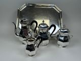 a silver tray with a silver tea set on top of it