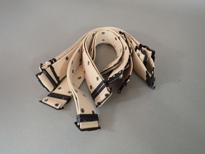 two belts are tied together on a table with a white background